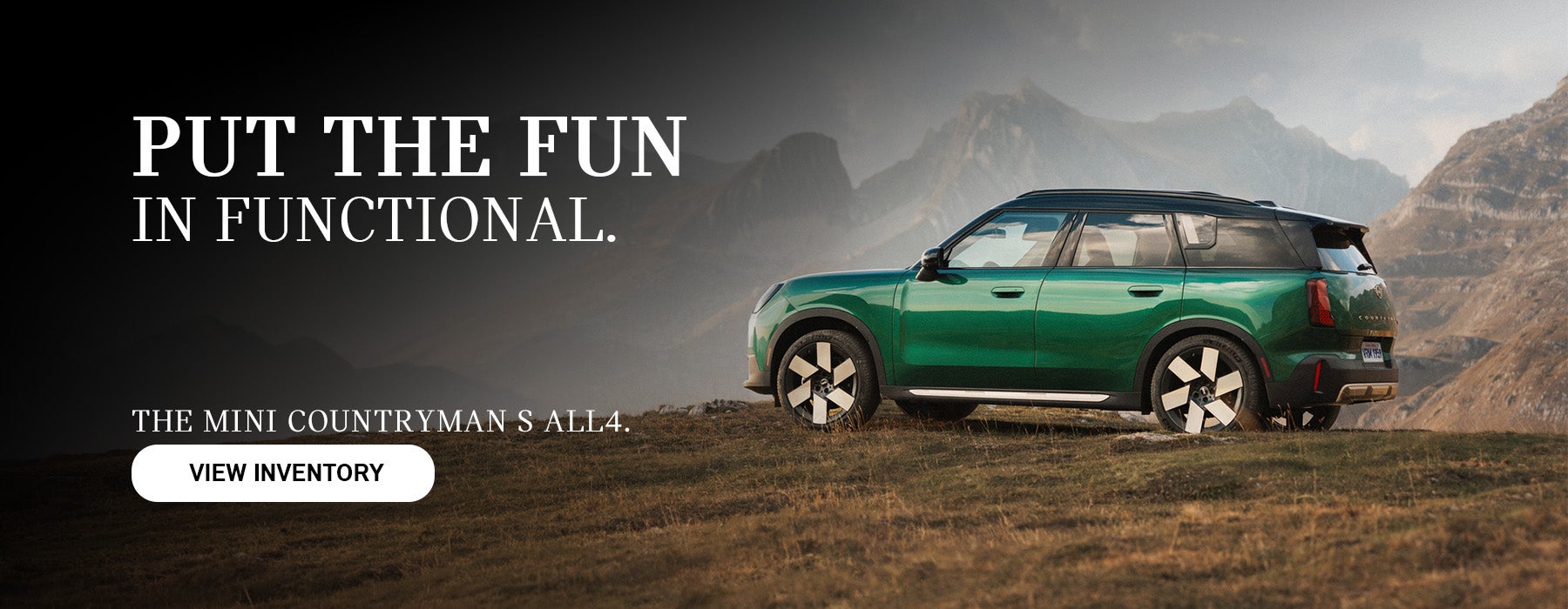 Green MINI Countryman parked on top of a hill.