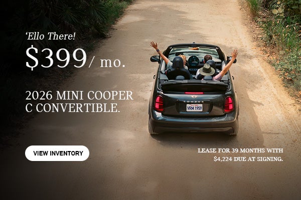 Gray MINI Convertible driving on a dirt path.
