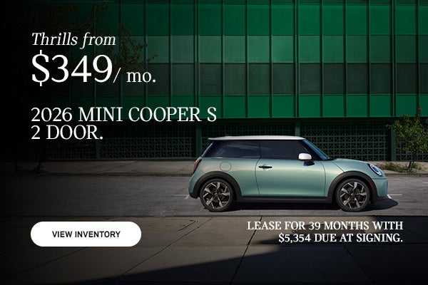 Side view of a green MINI 2 door parked on the road. 