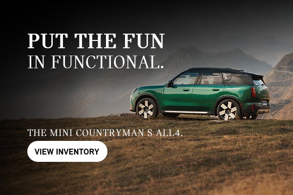 Green MINI Countryman parked on top of a hill.
