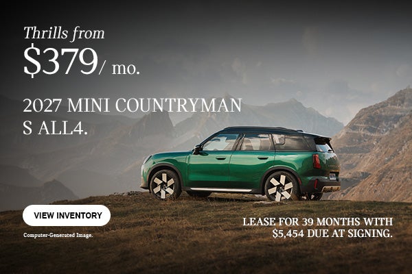 Side view of a green countryman parked on the top of a hill.
