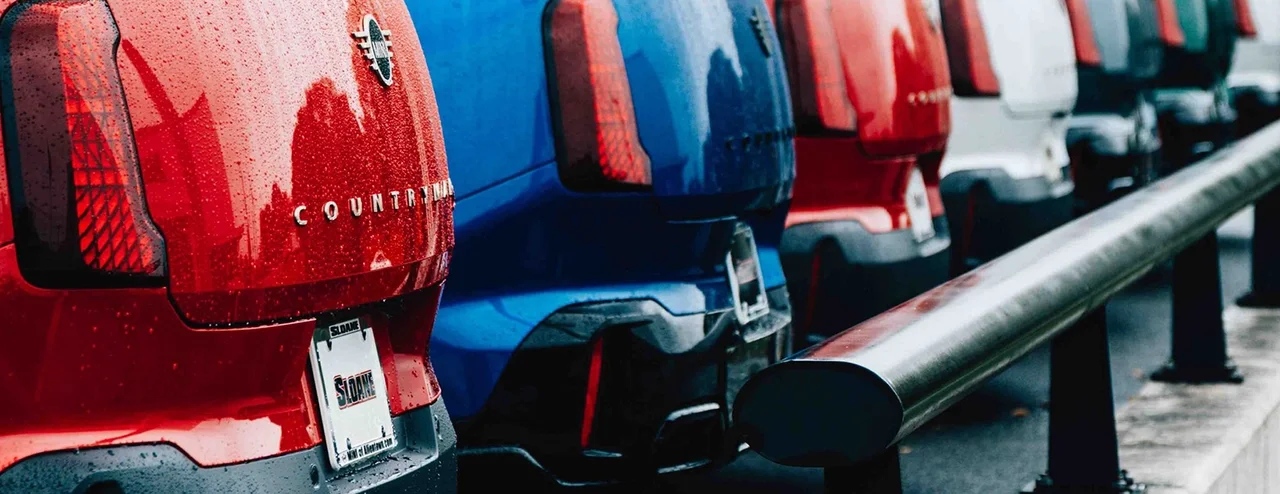 A row of MINI Countrymans on the lot at MINI of Allentown in Pennsylvania, including models in Chili Red II and Blazing Blue Metallic.